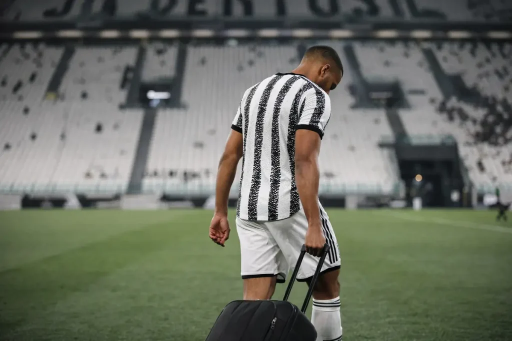 Bremer con la valigia in mano mentre esce a testa bassa dallo Juventus Stadium